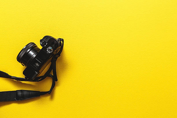 Camera on yellow background Camera on yellow background. camera photographic equipment stock pictures, royalty-free photos & images