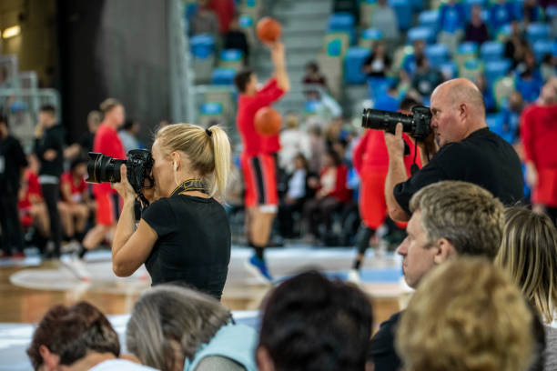 câmera pessoa tirando foto durante jogo de basquete - estádio e camera - fotografias e filmes do acervo