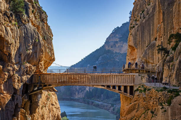Caminito del Rey canyon and view an old bridge in the front. People walk on the new one in the back. stock photo