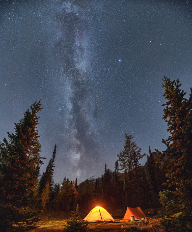 Camping tents with milky way and starry in the night sky on campsite in autumn forest at national park