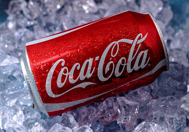 Can of Coca-Cola on ice Minsk, Belarus - August 16, 2015: Minsk, Belarus - August 16, 2015: Can of Coca-Cola on a bed of ice over a blue background cola stock pictures, royalty-free photos & images