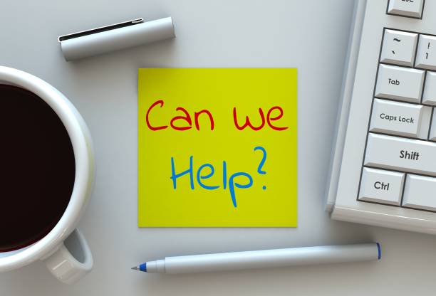 Can We Help, message on note paper, computer and coffee on table stock photo