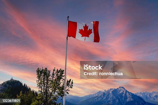istock Canada Flag and Sunset Over Canadian Rockies at Banff National Park 1323611801