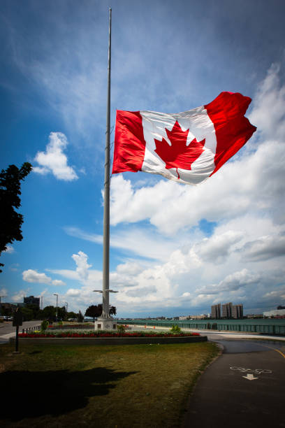 Canadian Flag at Half Mast in Windsor, Ontario, Canada The Canadian Flag flying at half mast in Windsor, Ontario, Canada. flag at half staff stock pictures, royalty-free photos & images