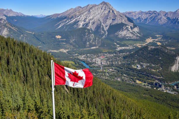 Canadian flag with rocky mountain background stock photo