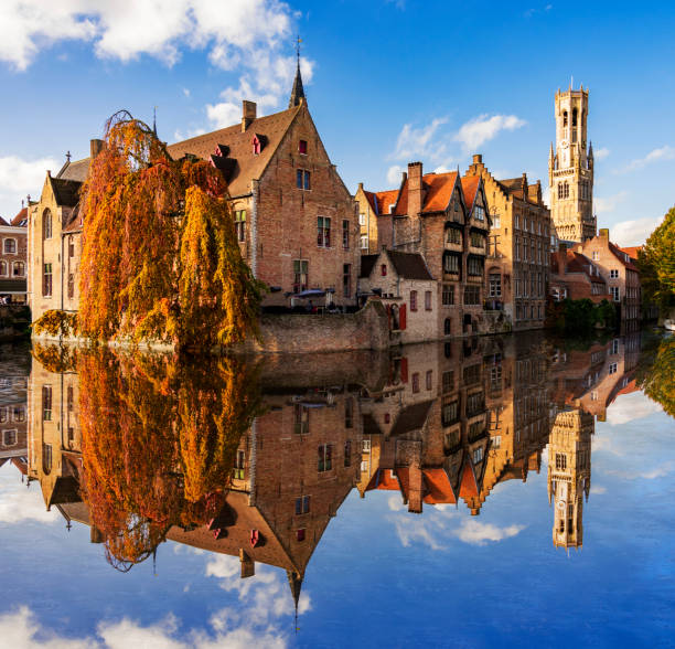 Canals and Buildings of Bruges in Belgium in autumn View from the Rozenhoedkaai with the Perez de Malvenda house and Belfort van Bruges in the background and pleasure boats brugge, belgium stock pictures, royalty-free photos & images