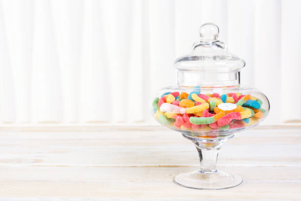 Candies in candy jar Candies in candy jar on wood table. candy jar stock pictures, royalty-free photos & images