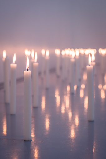 A low angle image of a huge group of wax candles all lit up with selective foreground focus Cape Town South Africa