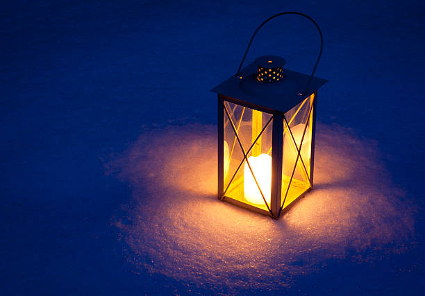 Candle lamp isolated in snow at night stock photo