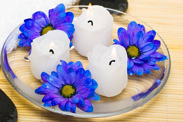 candles in water with blue flowers and towel