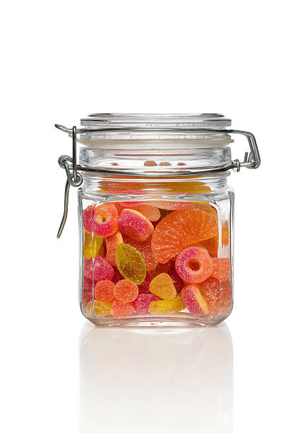 Candy jar on white background. Jar filled with brightly colored sweets. candy jar stock pictures, royalty-free photos & images