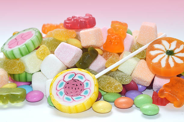 Candy, lollipop, colored smarties and gummy bears background stock photo