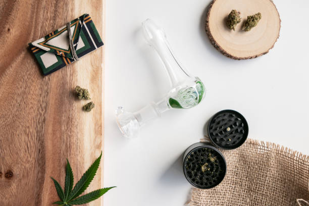 Cannabis Herb and Wood Setting with Weed Pouch, Nugs, Marijuana Pipe and Accessories, with Marijuana Leaf - Top Down stock photo