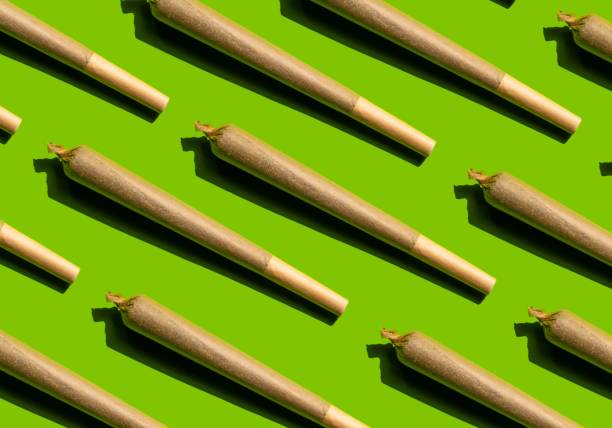 Cannabis joint pattern on green background. stock photo