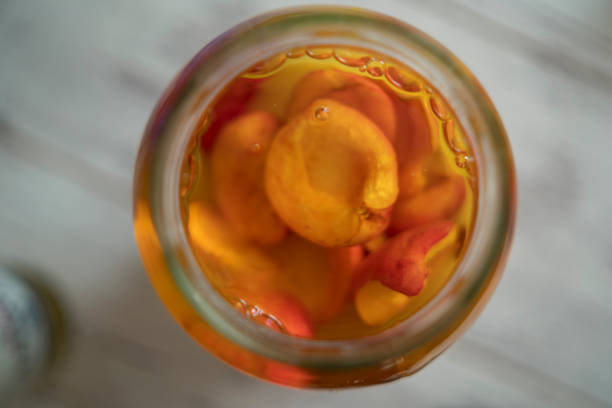 ingeblikte perziken fruit in een glazen pot - mitrovic stockfoto's en -beelden