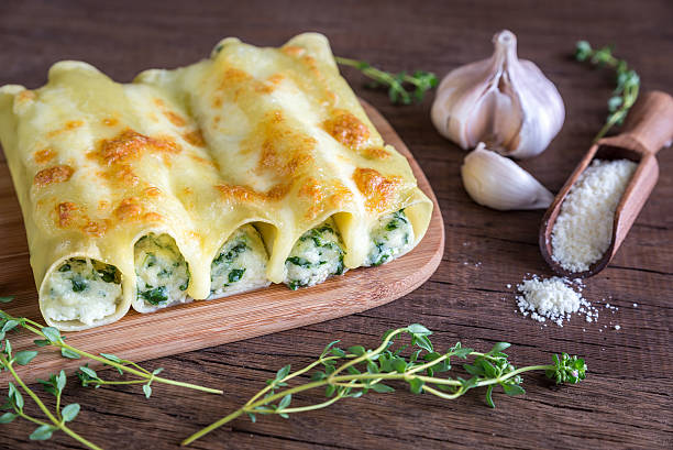 Cannelloni with ricotta and spinach on the wooden board stock photo