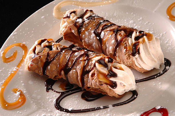Cannoli 2 cannoli on plate with powdered sugar cannoli stock pictures, royalty-free photos & images