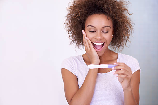 I can't believe it! Shot of a young woman looking at the results on her pregnancy test positive pregnancy test stock pictures, royalty-free photos & images