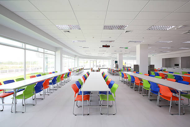 Canteen Canteen interior with white table and blue, green, orange chairs. cafeteria stock pictures, royalty-free photos & images