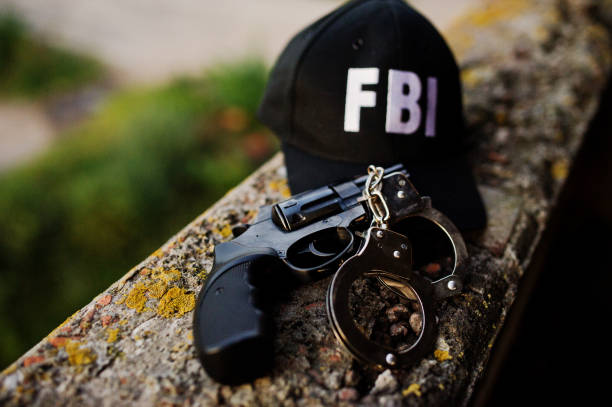리볼버와 갑 fbi 모자입니다. - fbi 뉴스 사진 이미지