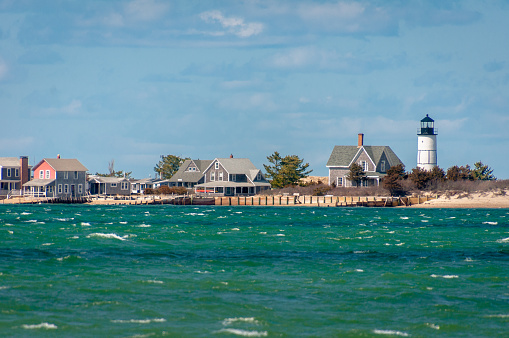 The Cape Cod  cottage colony and lighthouse at the tip of  Sandy Neck Peninsula in Barnstable, Massachusetts