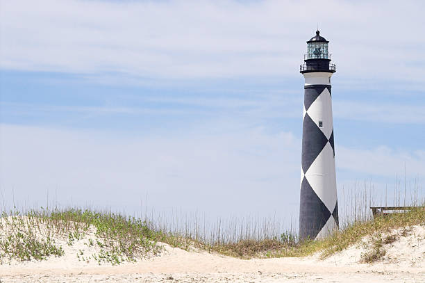 Cape Lookout Lighthouse A historic lighthouse guiding ships away from rocky shoals. north carolina beach stock pictures, royalty-free photos & images