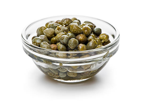 Capers transparent bowl of marinated capers isolated on white. More pictures... caper stock pictures, royalty-free photos & images