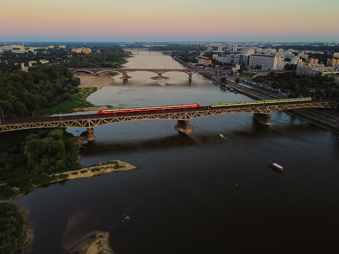 Capital cityscape and a suspension bridge over a large river. Drone, aerial view