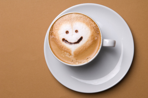 Cup of cappuccino with smiley face.