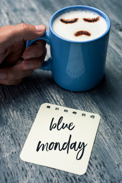 капучино с грустным лицом и текст синий понедельник - blue monday стоковые фото и изображения