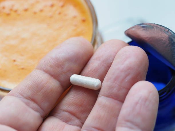 capsule vitamin D powder in  human hand for taking with food. branded blue packaging stock photo