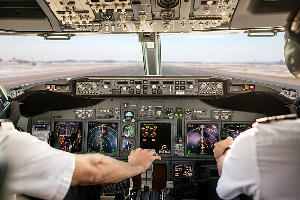 Captain pulling an aircraft throttle Captain is pulling an aircraft throttle, while first officer is piloting and taking off. Pilots are sitting in Boeing 737-800. airfield photos stock pictures, royalty-free photos & images