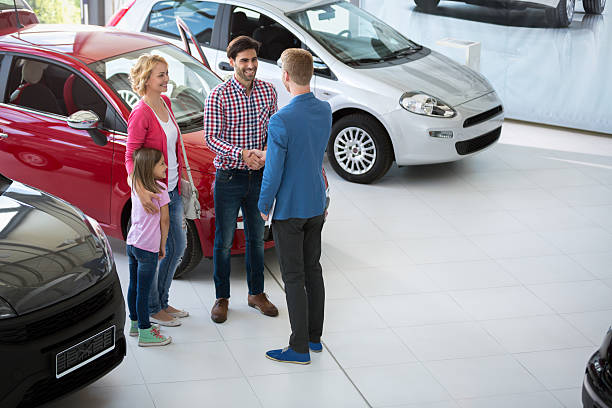 car agent congratulate the family car agent handshake with his daddy and congratulate the family on buying car car salesperson stock pictures, royalty-free photos & images