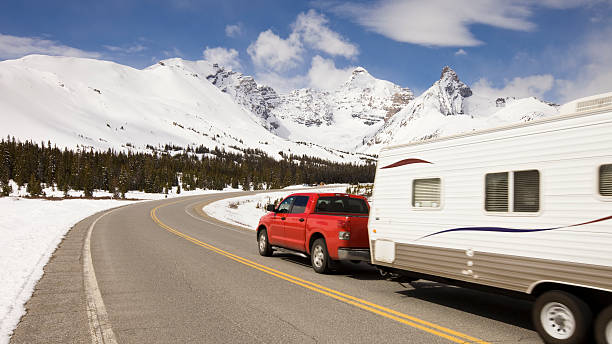 car and travel trailer in the mountains - caravan stockfoto's en -beelden
