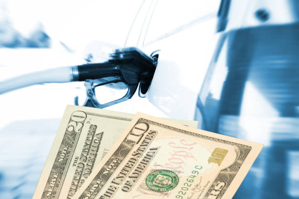 Car at a gas station and dollar bills stock photo