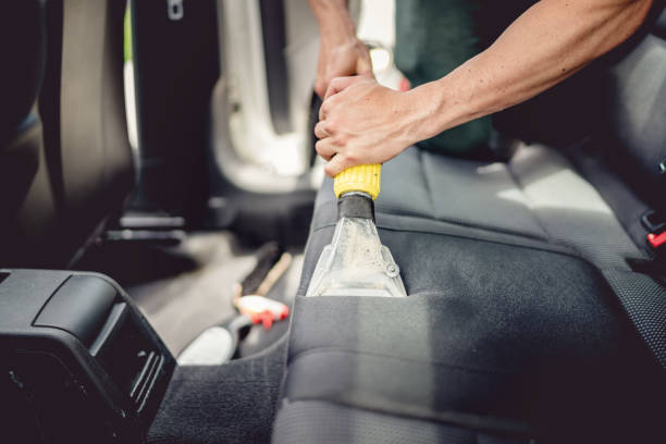 Car detailing and car care concept - Professional using steam vacuum for draining stains stock photo