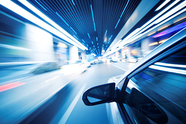 A car driving through a tunnel at night stock photo