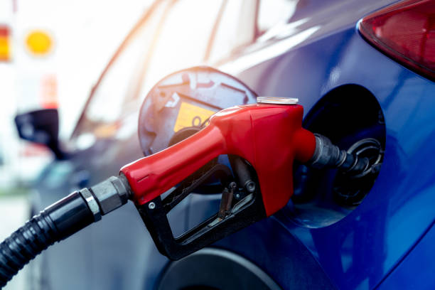 Car fueling at gas station. Refuel fill up with petrol gasoline. Petrol pump filling fuel nozzle in fuel tank of car at gas station. Petrol industry and service. Petrol price and oil crisis concept. stock photo