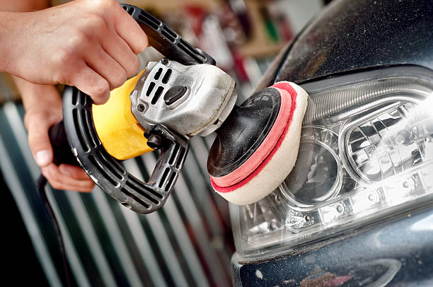 Car headlight cleaning with power buffer machine stock photo
