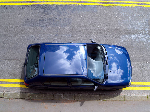 Car illegally parked on double yellow lines from above stock photo