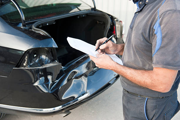 Car inspections Service engineer inspecting a black car after a crash. dented stock pictures, royalty-free photos & images
