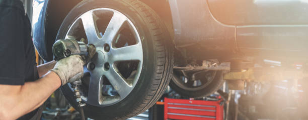 mecânico de carro aparafusando a roda na oficina de reparação automóvel - serviço de bordo - fotografias e filmes do acervo