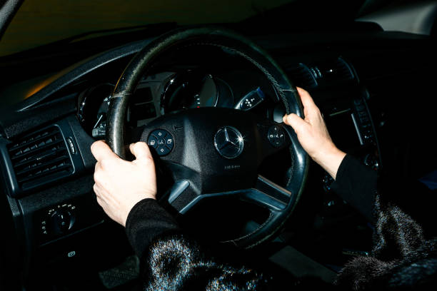Car Mercedes-Benz R 350. Woman driving a car. Women's hands hold the steering wheel. stock photo