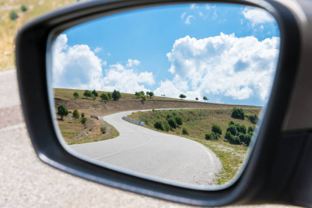 Car mirror and road. Mountain winding road in the rearview mirror of the car. dangerous road. Car mirror and road. rear view mirror stock pictures, royalty-free photos & images