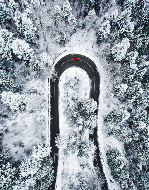 Car on winding winter road as seen from above stock photo