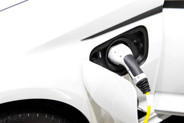 Car or Electric vehicle at charging cable plugged into the side of electric car. Eco-friendly sustainable energy concept. stock photo