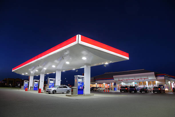 car refueling at gas station during the night - reparationsverkstad bildbanksfoton och bilder