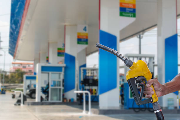 Car refueling on the petrol station. male employees controlled the fuel pump with Fuel nozzles adding gasoline fuel in car at a pump gas station stock photo