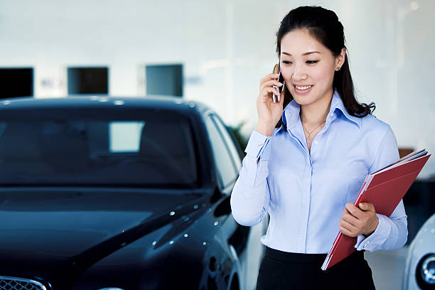 Car saleswoman is on the phone stock photo
