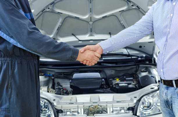 Car service. Mechanic and customer shaking hands. Excellent cooperation between car mechanic and customer. auto mechanic stock pictures, royalty-free photos & images